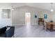 Bright, open living room boasts vaulted ceiling, gray flooring, and plentiful natural light at 26800 Racquet Cir, Leesburg, FL 34748