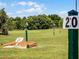 Scenic view of a recreation area with markers on the green, with blue skies and lush trees in the background at 26800 Racquet Cir, Leesburg, FL 34748