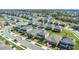 An aerial view of a community with two-story homes, featuring manicured lawns and mature trees at 3054 Hill Point St, Minneola, FL 34715