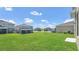 Large grassy backyard with views of neighboring houses and blue skies at 3054 Hill Point St, Minneola, FL 34715