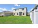 Backyard view of a two-story home with a green lawn and a privacy fence at 3054 Hill Point St, Minneola, FL 34715