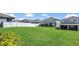 Large backyard showcasing a well-maintained lawn enclosed by a white fence and neighboring homes at 3054 Hill Point St, Minneola, FL 34715