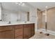Bathroom featuring double sinks, large mirror, and tiled shower with glass door at 3054 Hill Point St, Minneola, FL 34715