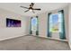 Bedroom with two windows, ceiling fan, and mounted TV at 3054 Hill Point St, Minneola, FL 34715