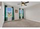 Bedroom with neutral carpet, ceiling fan, and windows with sheer green curtains at 3054 Hill Point St, Minneola, FL 34715