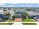 Two-story home featuring a brick driveway, well-maintained lawn, and lush landscaping at 3054 Hill Point St, Minneola, FL 34715
