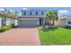 Beautiful home featuring a brick driveway, lush lawn, and manicured landscaping at 3054 Hill Point St, Minneola, FL 34715