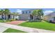 Attractive two-story home with a red brick driveway, green lawn, and palm tree at 3054 Hill Point St, Minneola, FL 34715