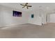 Spacious living room featuring plush carpeting, a modern ceiling fan, and modern neutral paint at 3054 Hill Point St, Minneola, FL 34715