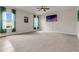 Expansive living room with plush carpeting, ceiling fan, modern neutral paint, and sheer curtains at 3054 Hill Point St, Minneola, FL 34715