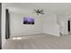 Spacious living room featuring neutral carpet, ceiling fan, and large-screen TV at 3054 Hill Point St, Minneola, FL 34715
