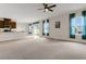 Open-concept living area adjacent to the kitchen, featuring a ceiling fan and sheer curtains at 3054 Hill Point St, Minneola, FL 34715