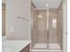Modern walk-in shower equipped with sliding glass doors, a built-in bench, and neutral tiles at 3054 Hill Point St, Minneola, FL 34715
