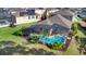 Aerial view of a backyard with screened pool, landscaping, and neighborhood rooftops at 306 Orista Dr, Davenport, FL 33897