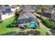 Aerial view of backyard featuring a screened-in pool, complemented by lush landscaping at 306 Orista Dr, Davenport, FL 33897