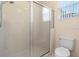 Clean bathroom featuring a glass-enclosed shower, toilet, and a window for natural light at 306 Orista Dr, Davenport, FL 33897