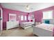 A pink bedroom featuring two twin beds, a ceiling fan and carpeted floors at 306 Orista Dr, Davenport, FL 33897