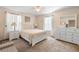 A light and airy bedroom showcasing a white bed frame, neutral carpet and white dresser at 306 Orista Dr, Davenport, FL 33897