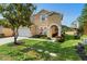 Charming two-story home showcasing a well-manicured lawn and beautiful landscaping at 306 Orista Dr, Davenport, FL 33897