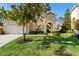 Charming home exterior with manicured lawn, a cozy entrance, and an attached garage at 306 Orista Dr, Davenport, FL 33897