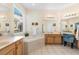 Bright bathroom featuring double sinks, a soaking tub, and a separate vanity area at 306 Orista Dr, Davenport, FL 33897