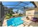 The backyard features a sparkling pool and a large, screened-in patio at 306 Orista Dr, Davenport, FL 33897