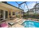 A screened-in patio with an outdoor dining area and a sparkling swimming pool at 306 Orista Dr, Davenport, FL 33897