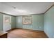 Cozy bedroom with light green walls, wood floors, and a bright window overlooking the yard at 33311 Green Rd, Leesburg, FL 34788