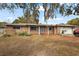 Inviting single story brick home with a covered entry, mature trees, and attached garage at 33311 Green Rd, Leesburg, FL 34788
