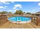 Backyard above ground pool with wooden deck surround and white ladder at 33311 Green Rd, Leesburg, FL 34788