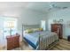 Comfortable main bedroom featuring a metal bed frame, neutral decor, and natural light from large windows at 3346 Wise Way, The Villages, FL 32163