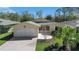 Charming home with a brick driveway, a two-car garage, and mature landscaping at 341 Ranchwood Dr, Leesburg, FL 34748