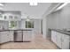 Open-concept kitchen boasts white cabinets, tile flooring, and views of the surrounding greenery at 341 Ranchwood Dr, Leesburg, FL 34748