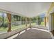 Sunroom features tile flooring, screens, curtains, and serene backyard views at 341 Ranchwood Dr, Leesburg, FL 34748