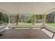 Enclosed lanai featuring tile flooring, neutral decor, and views of the lush backyard at 341 Ranchwood Dr, Leesburg, FL 34748