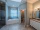 Spacious bathroom with tile floors, a tub, and a separate shower with a granite vanity at 351 Groveland Rd, Mount Dora, FL 32757