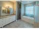 Bathroom with tub, separate shower, white cabinets and granite counters at 351 Groveland Rd, Mount Dora, FL 32757