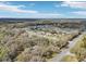 Expansive aerial view of a quiet rural neighborhood surrounded by lush trees and clear blue skies at 3909 Cr 532A, Bushnell, FL 33513