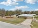 Aerial view of a home with a large yard, mature trees, and a long driveway at 3909 Cr 532A, Bushnell, FL 33513