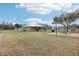 Expansive backyard featuring a screened-in patio and designated firepit area, perfect for outdoor relaxation at 3909 Cr 532A, Bushnell, FL 33513