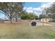 A spacious backyard featuring a fire pit area with chairs, a storage shed, and mature trees at 3909 Cr 532A, Bushnell, FL 33513
