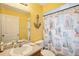 Bright yellow bathroom with beach themed shower curtain, anchor decor and a modern sink at 3909 Cr 532A, Bushnell, FL 33513