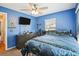 Bright blue bedroom with ceiling fan, carpet flooring, and two windows providing natural light at 3909 Cr 532A, Bushnell, FL 33513