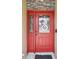 Inviting red front door with decorative wreath and stone accents, enhancing the curb appeal of the home at 3909 Cr 532A, Bushnell, FL 33513