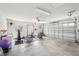 Spacious garage with exercise equipment, high ceilings and white walls and a large open door at 3909 Cr 532A, Bushnell, FL 33513
