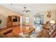 Comfortable living room featuring hardwood floors, cozy seating, and a sliding glass door leading to the lanai at 3909 Cr 532A, Bushnell, FL 33513