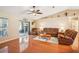 Inviting living room with hardwood floors, comfortable seating, and access to a screened lanai, perfect for indoor-outdoor living at 3909 Cr 532A, Bushnell, FL 33513