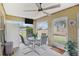 Cozy sunroom with a ceiling fan, dining table, screened windows, and view of the backyard at 3909 Cr 532A, Bushnell, FL 33513