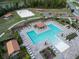 Stunning aerial view of a community pool, playground, and beach volleyball court with plenty of lounge chairs and greenery at 412 Lady Bella Pl, Deland, FL 32724