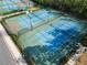 Aerial view of multiple blue and green tennis and pickleball courts with surrounding trees at 412 Lady Bella Pl, Deland, FL 32724
